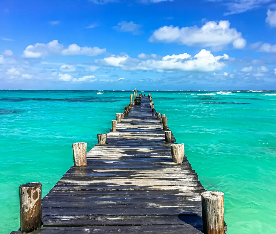 Muelle de madera sobre agua turquesa en la zona hotelera de Cancún